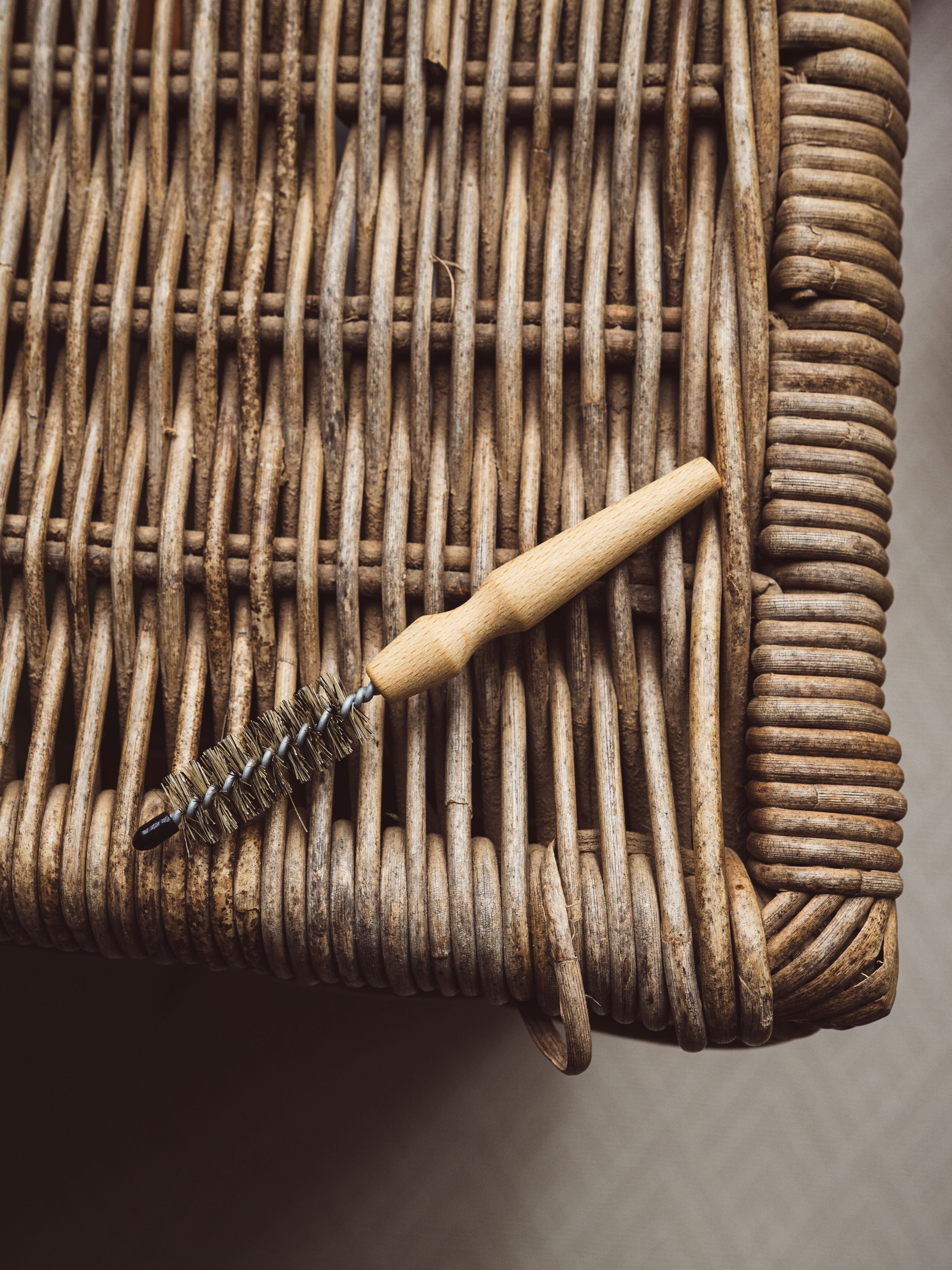 Bristle brush with wooden handle on a wicker surface